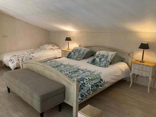 2 lits dans une chambre avec 2 tables et 2 lampes dans l'établissement Château de la Merletade, à Cheval-Blanc