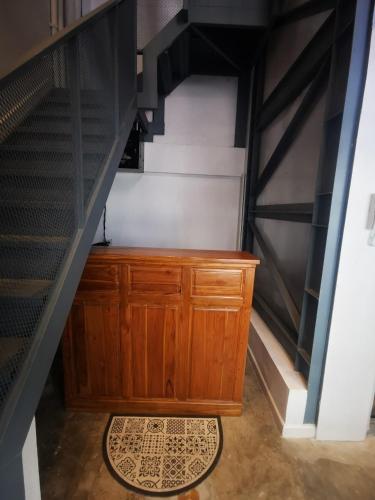 a stairway with a wooden cabinet in a room at BPP Resident near Donmueang Airport in Ban Don Muang