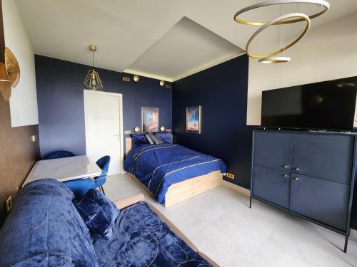 une chambre avec deux lits et une télévision à écran plat dans l'établissement L'ASTRONAUTE - Balcon vue mer - CLIM - place parking privée - Marina baie des anges, à Villeneuve-Loubet