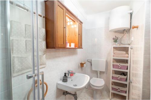 bagno bianco con lavandino e servizi igienici di Studio Izola a Izola