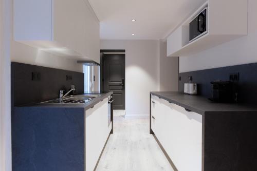 - une cuisine avec des comptoirs en noir et blanc et un évier dans l'établissement L'Ardoise, L'Anjou, La Vigne et La Loire, à Angers