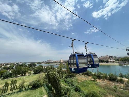 dos teleféricos azules en un cable sobre un río en Apart Khujand en Khujand