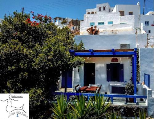 a house with blue trim and people sitting on the roof at 'La Casa della Sirena 2' in Plaka Milou