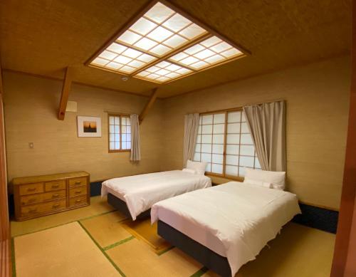 a bedroom with two beds and a skylight at Annupuri Retro Lodge in Niseko