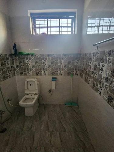 a bathroom with a toilet and a window at Shanti Niwas in Varanasi