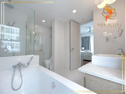 Cormar KLCC Suites By NHB في كوالالمبور: حمام مع حوض استحمام ودش ومغسلة