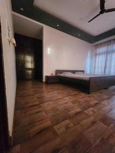 - une chambre avec un lit et du parquet dans l'établissement Shanti Niwas, à Varanasi