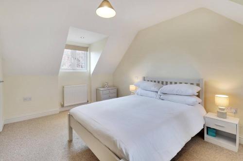 a bedroom with a white bed with two pillows at Pass the Keys Cute cottage in Pembury with parking in Pembury