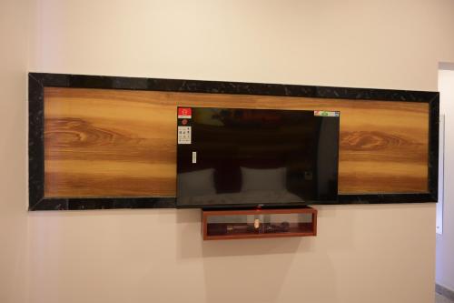 TV de pantalla plana colgada en la pared en Ramraj Resort en Kanyakumari