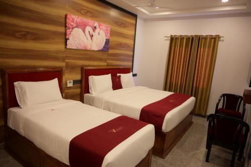 a hotel room with two beds and a painting on the wall at Ramraj Resort in Kanyakumari