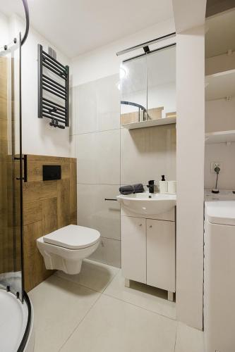a white bathroom with a toilet and a sink at U Księcia Józefa in Pruszków