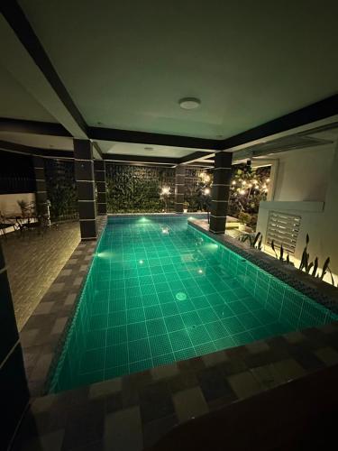 a large swimming pool in a building with a pool at Sts. Joachim and Ann Staycation house in Ulot