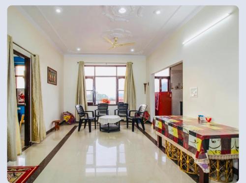 salon z łóżkiem, stołem i krzesłami w obiekcie Shriya home stay Palampur w mieście Palampur
