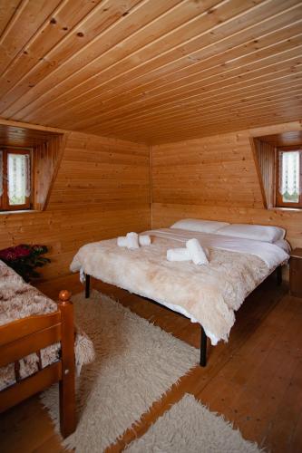 a bedroom with two beds in a log cabin at Kulla Pracja Theth in Theth