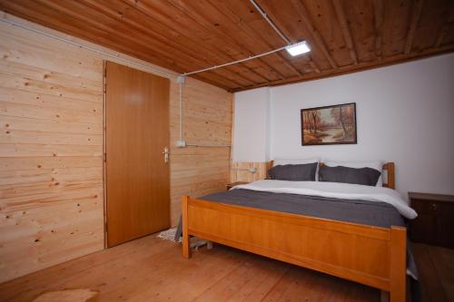 a bedroom with a bed and a wooden wall at Kulla Pracja Theth in Theth