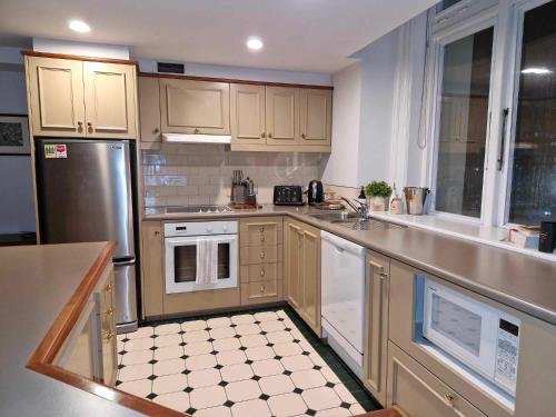 a kitchen with wooden cabinets and white appliances at McMahon Suite - Central CBD in Christchurch