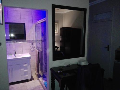 a bathroom with a sink and a shower with purple lights at Victoria Mea Est in Welkom