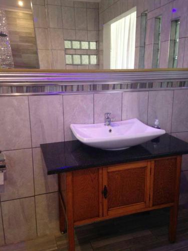 a bathroom with a sink and a mirror at Victoria Mea Est in Welkom