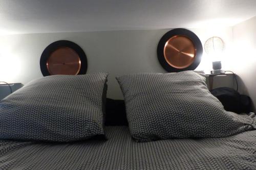 une chambre avec un lit avec deux oreillers et un miroir dans l'établissement Studio CENTRE proche PALAIS DES PAPES WIFI, à Avignon