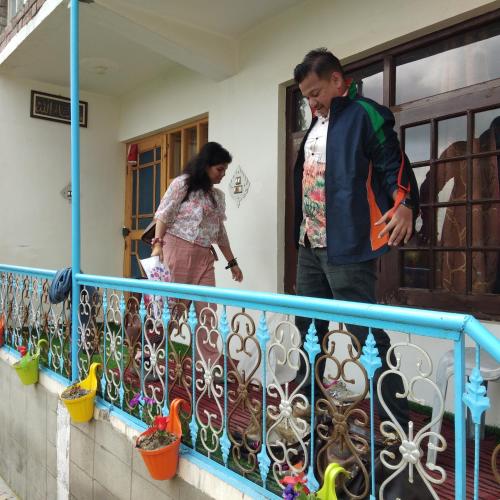 a man and a woman standing on a balcony at Elizabeth paying guest house Tangmarg gulmarg in Gulmarg