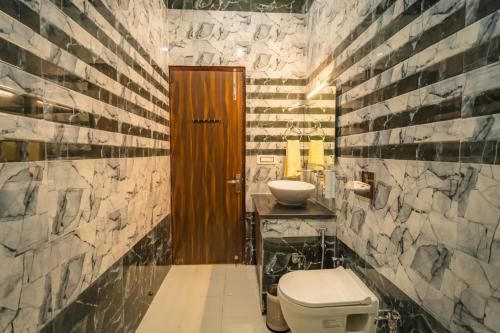 a bathroom with a toilet and a sink at Pristine Woods Resort in Dehradun