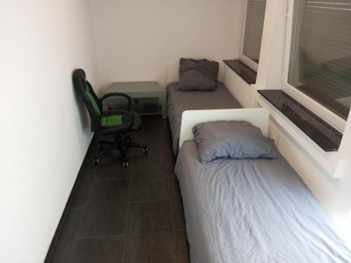 2 łóżka w pokoju z biurkiem i krzesłem w obiekcie Eve Zimmer in Heilbronn Zentrum w mieście Heilbronn