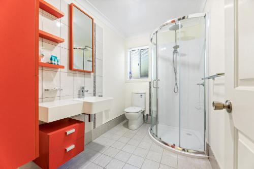 ein Badezimmer mit Dusche, Waschbecken und Toilette in der Unterkunft 1-3A Montague Street, Narooma in Narooma