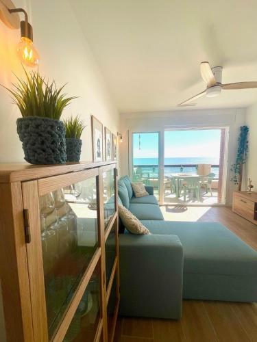 a living room with a blue couch and a view of the ocean at Casa Lua un espacio ideal para familias in Playa de Gandia