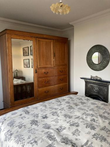 1 dormitorio con cama, tocador y espejo en Little Basset, en Kingsdown