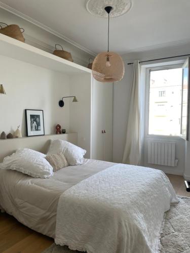 a bedroom with a white bed and a window at Grande chambre cosy in Marseille