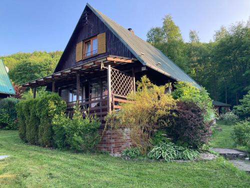 a large wooden house with a brick wall at Chata Koryška in Trojanovice