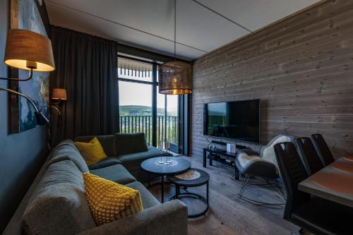 a living room with a couch and a television at Trysil Alpine Lodge in Trysil