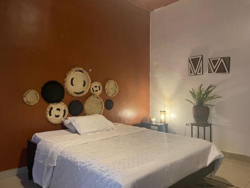 Un dormitorio con una cama con un montón de sombreros en la pared en grande villa verdoyante à louer pour 1 mois en Kigali