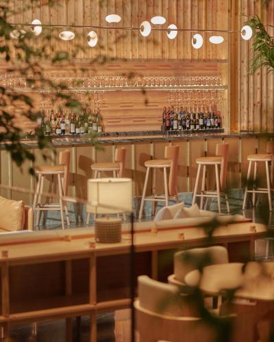 a restaurant with a bar with stools and wine bottles at Amara Singapore in Singapore