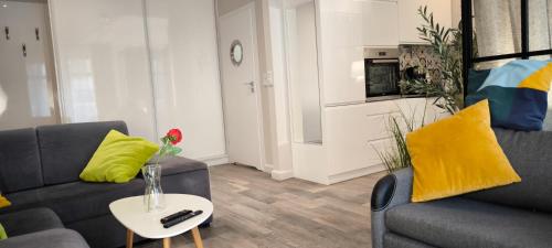 a living room with two couches and a table at Central Apartments Neptun Park 1 & Parking in Gdańsk