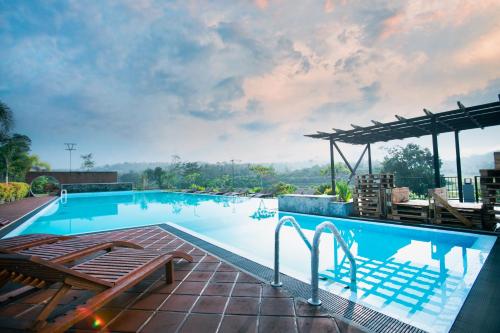 a large swimming pool with two chairs and a patio at Sueen Nature Resort in Hatton