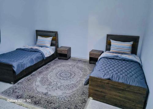um quarto com duas camas e um tapete em Superbe logement Majida boulila em Sfax