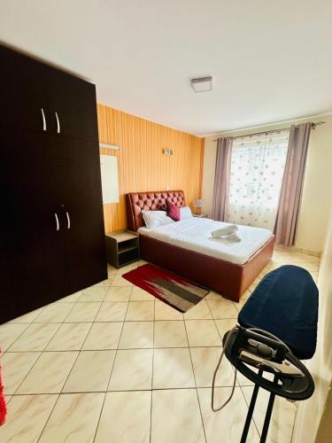 a bedroom with a bed and a chair in it at Milimani apartments10 in Nakuru