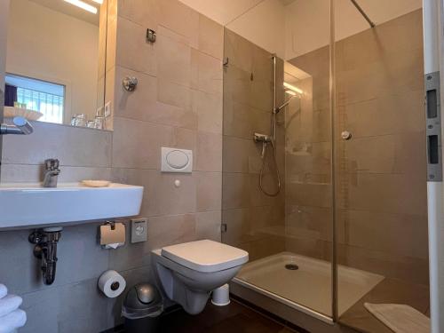 La salle de bains est pourvue d'une douche, de toilettes et d'un lavabo. dans l'établissement Apartmenthaus Gutenberg 78, à Potsdam
