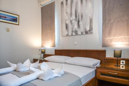 - 2 lits dans une chambre d'hôtel avec des oreillers blancs dans l'établissement V&GIO COZY APARTMENTS, à Nopíyia