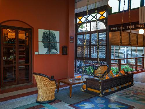 a living room with a table and chairs and a window at The House of MG-A Heritage Hotel, Ahmedabad in Ahmedabad