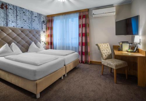 a hotel room with a bed and a chair at Hotel Schachner in Maria Taferl