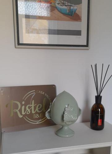 a white shelf with a clock and a vase on it at Ristel Casa Vacanza in Lizzano