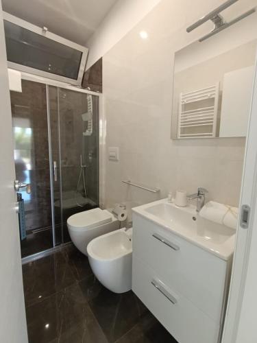 a bathroom with a toilet and a sink and a shower at Villetta Lu Sciardinu in Otranto