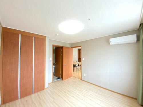 an empty room with a ceiling fan and a hallway at Jungheung Gold Spa & Resort in Naju