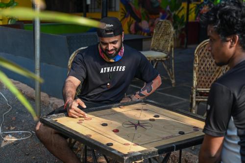 Un homme joue à un jeu sur une table dans l'établissement BunkNBrew, à Palolem