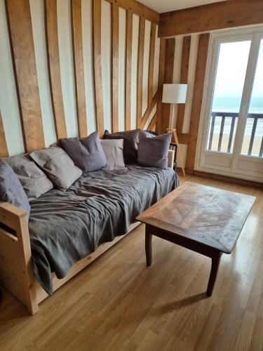 un salon avec un canapé et une table basse dans l'établissement Appartement vue mer, à Cabourg