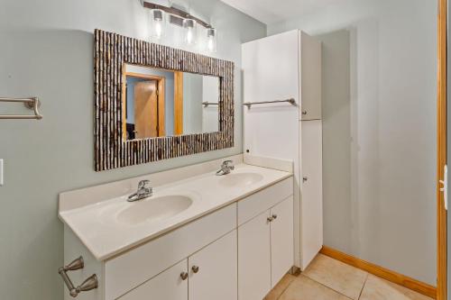a white bathroom with a sink and a mirror at 2067 Duck Days Soundfront w Pier in Duck