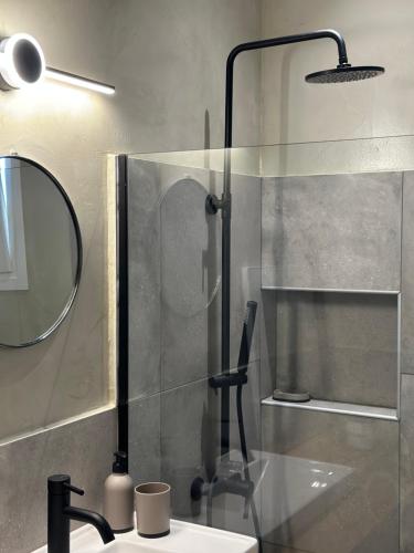 a bathroom with a shower with a sink and a mirror at 2 Doors in Kavala