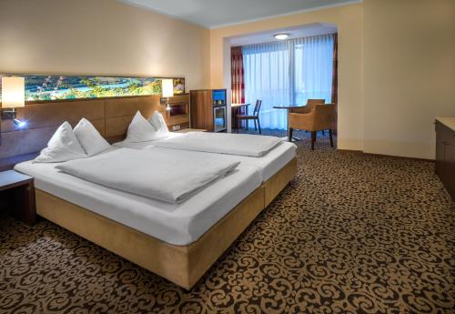a hotel room with a large bed and a desk at Hotel Schachner in Maria Taferl